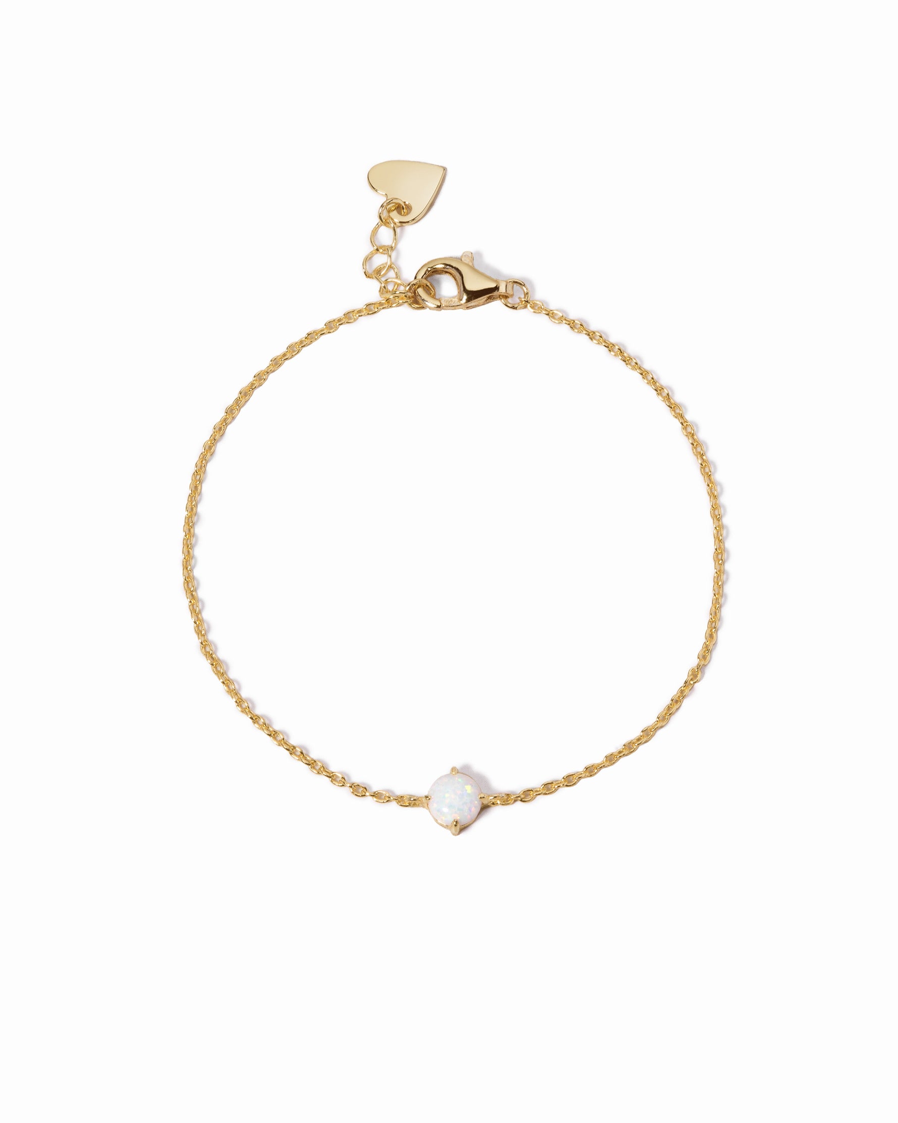 Gold bracelet with a small white opal stone on a white background