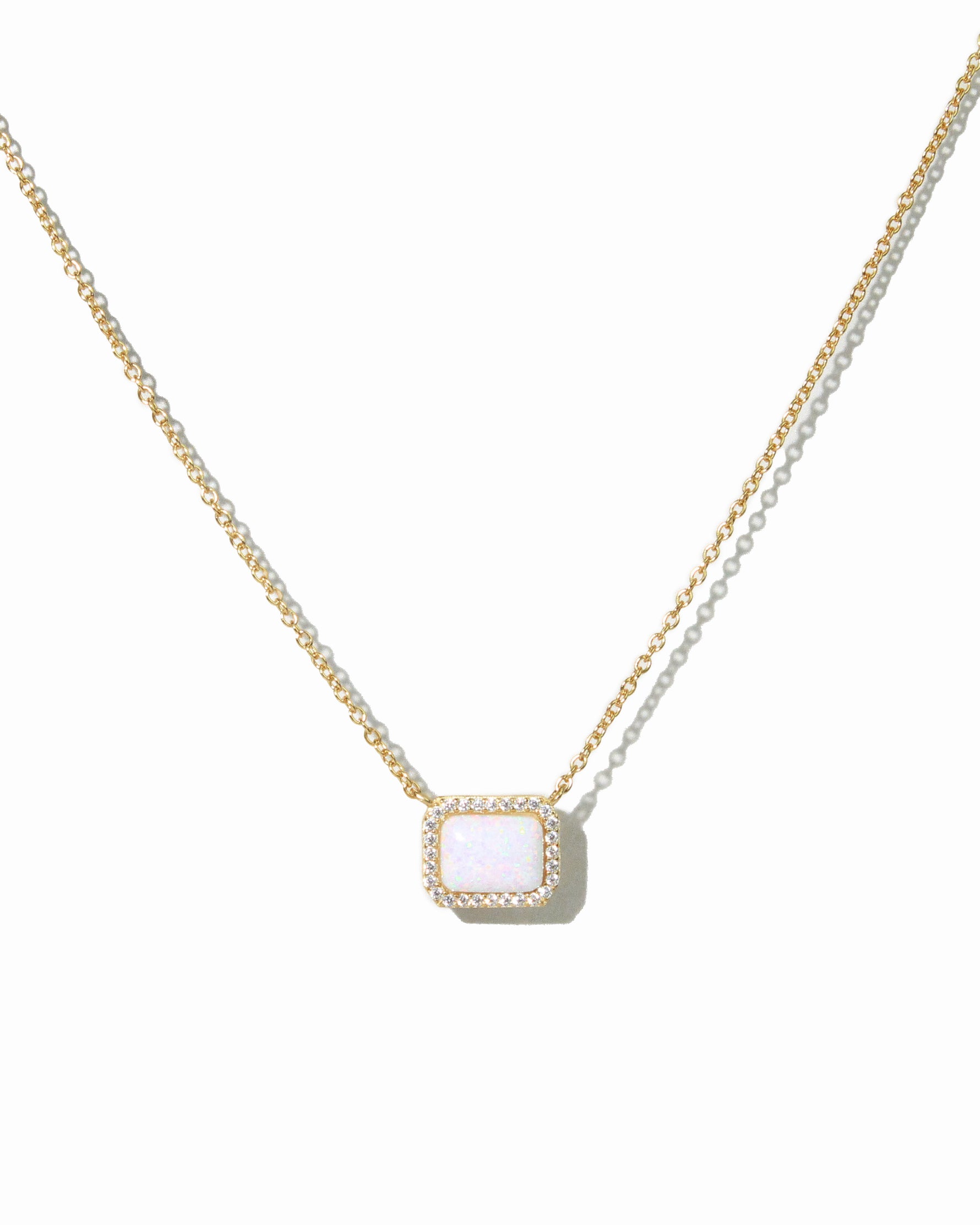 Gold necklace with rectangle opal pendant on white background