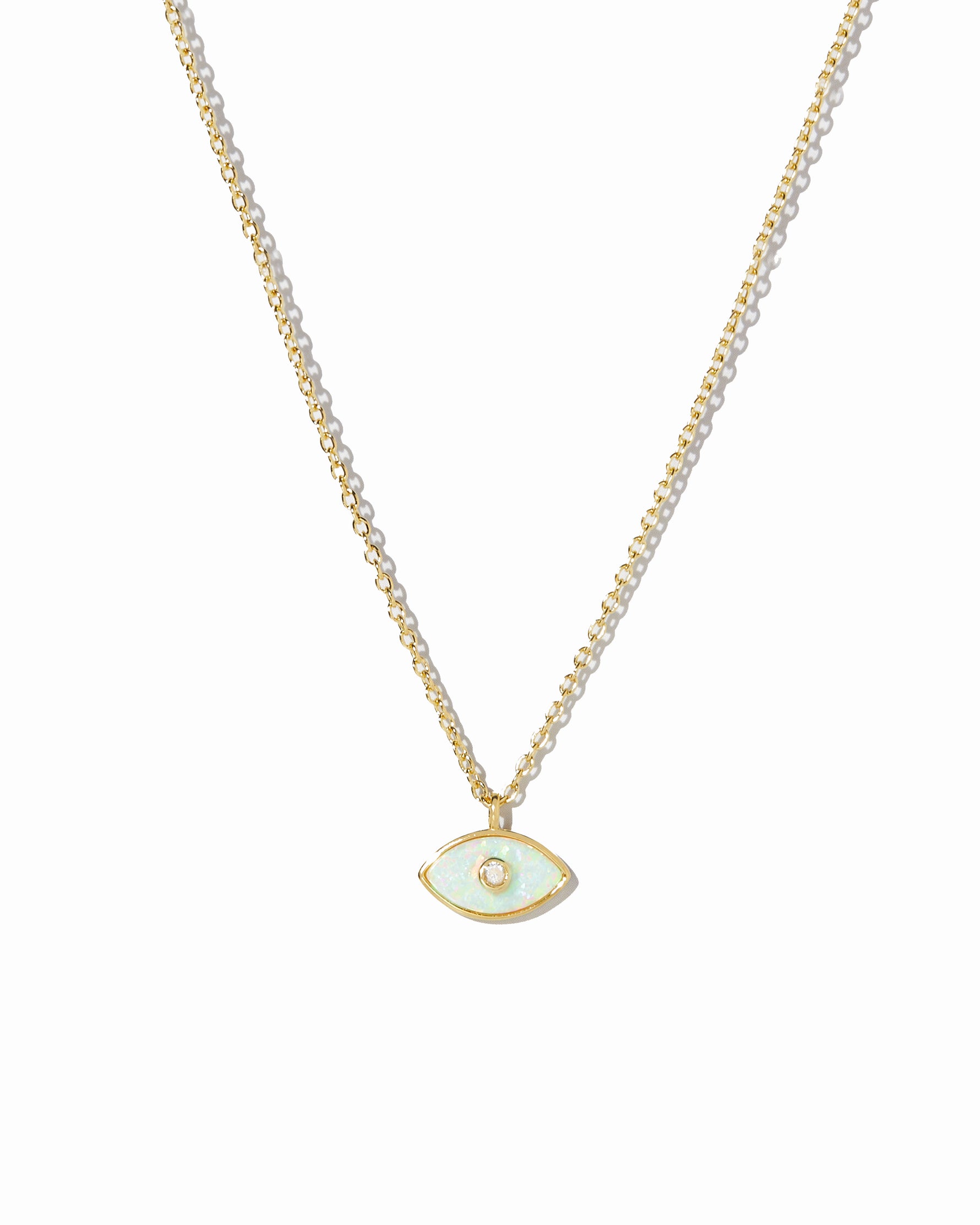 Gold necklace with a small evil eye opal pendant on a white background