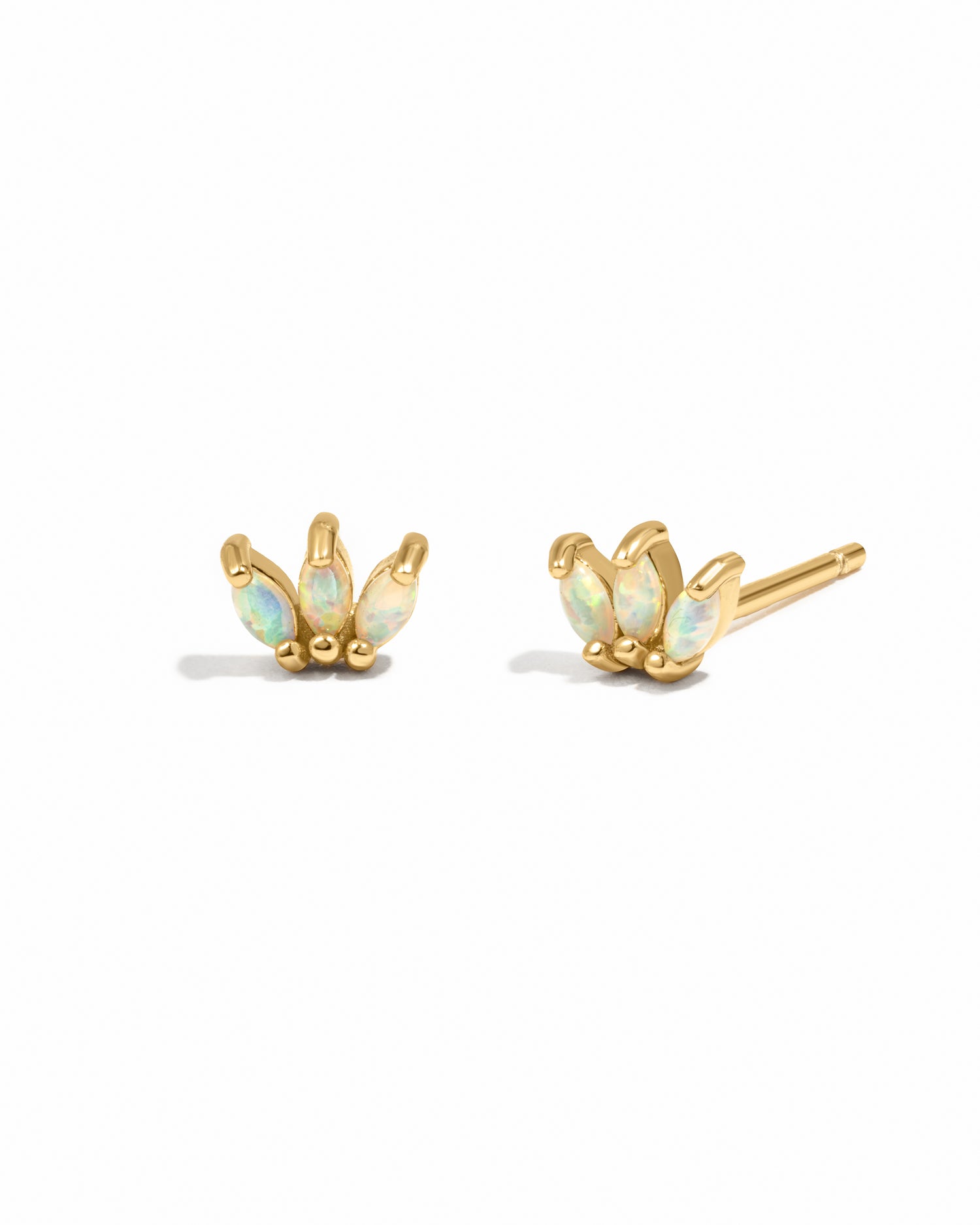 Pair of gold earrings with opal stones on a white background