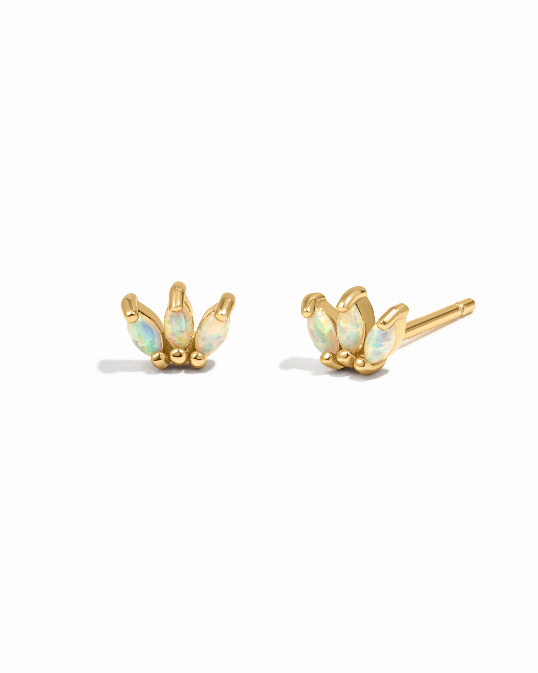 Pair of gold earrings with opal stones on a white background
