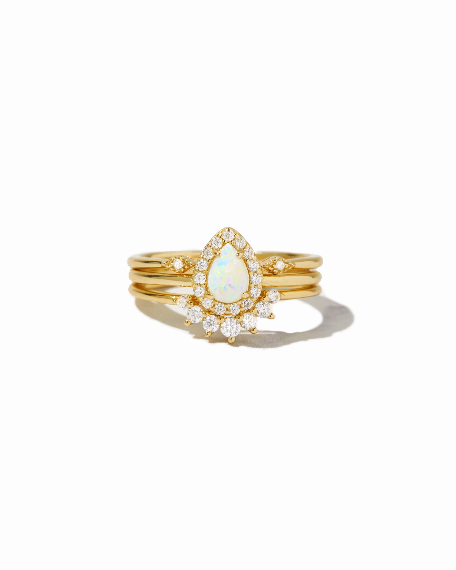 Gold ring with a central opal stone and smaller diamonds on a white background