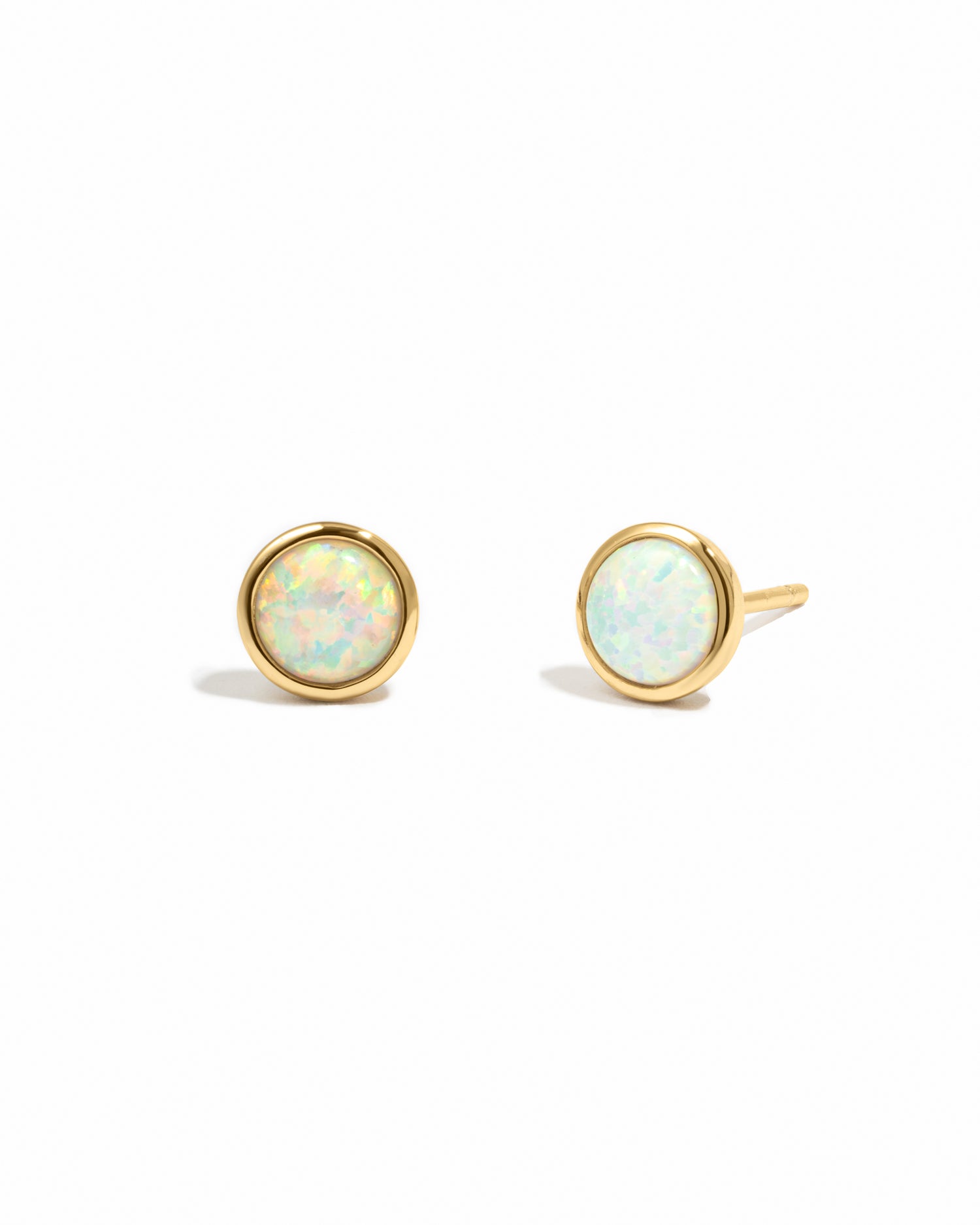 Gold earrings with opal stones on a white background