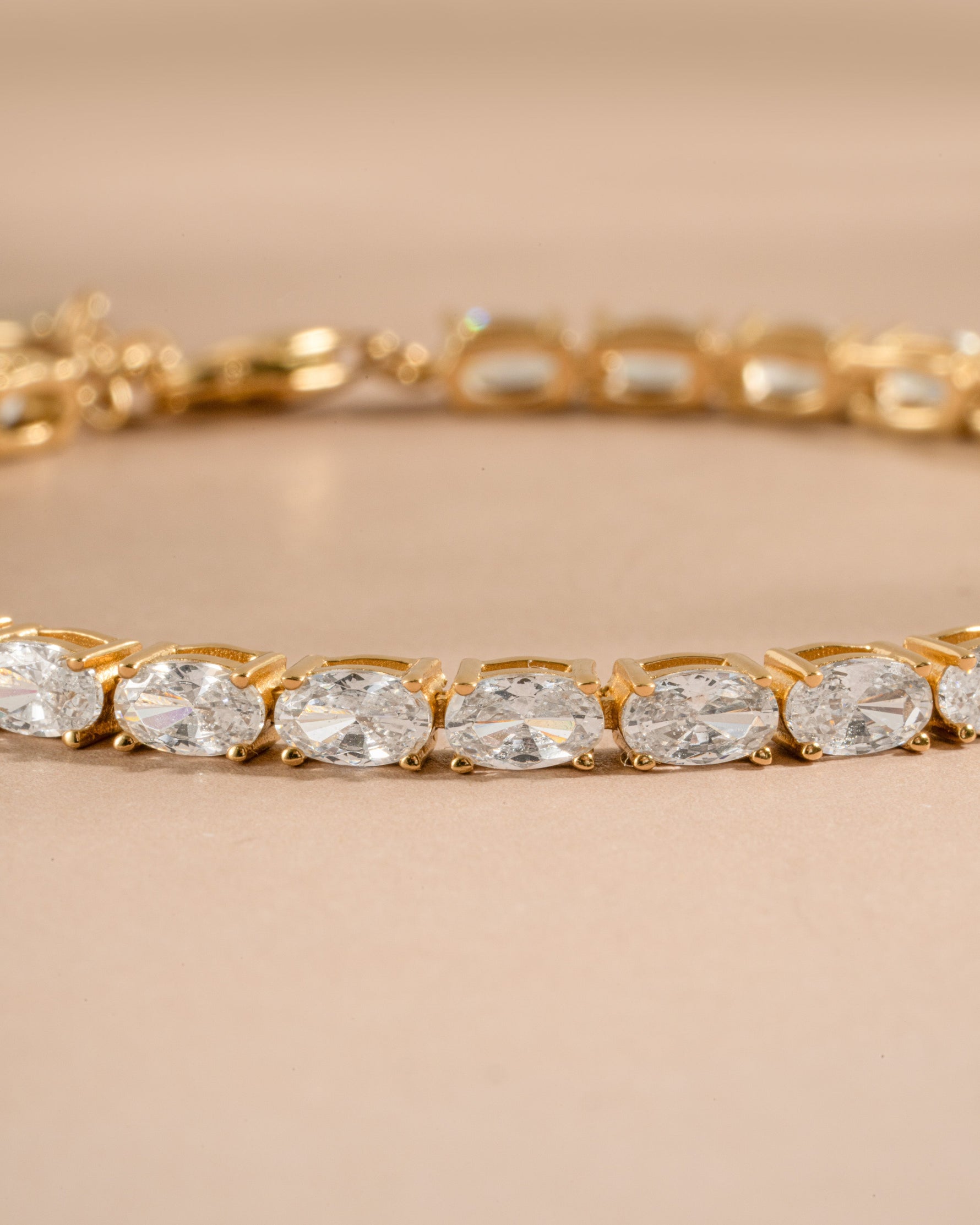 Gold oval diamond vintage bracelet laying on a neutral background