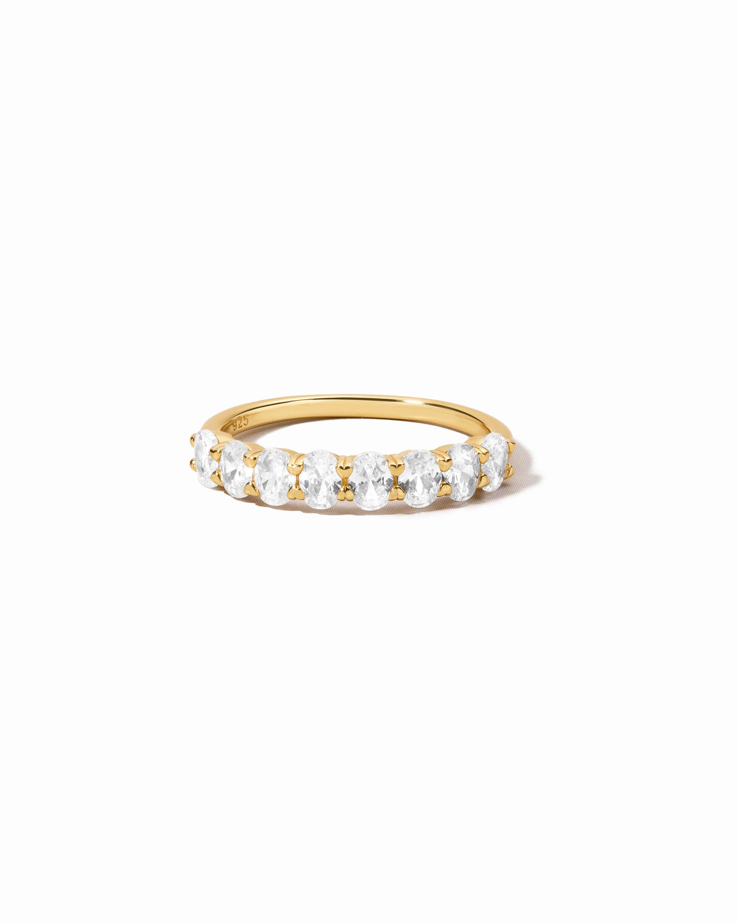 Gold ring with oval gemstones on a white background