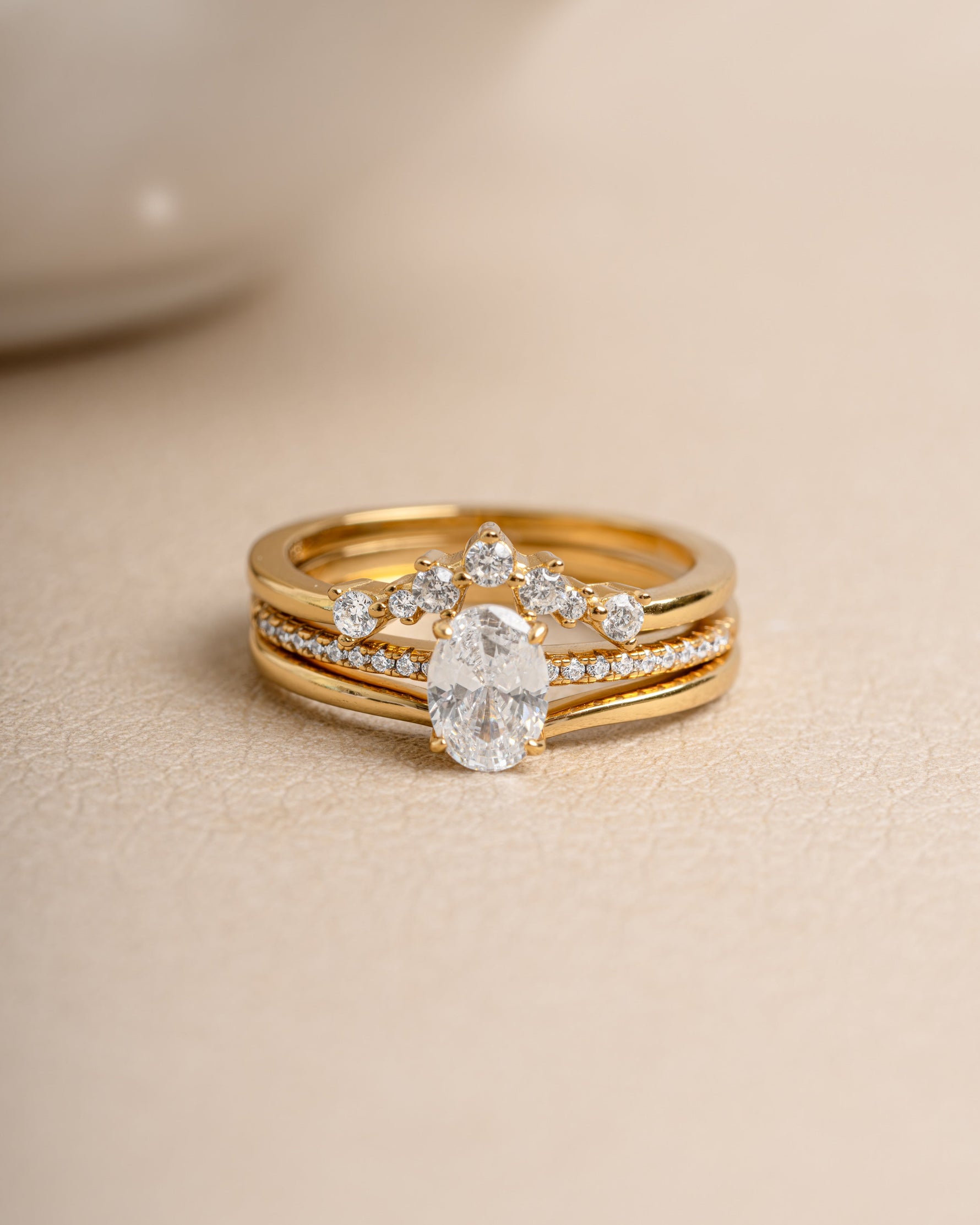 Gold diamond ring set on a beige background