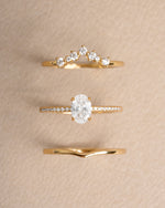 Gold oval dainty ring set on a beige background