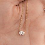 Model holding diamond necklace in gold