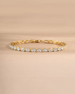 Gold cubic zirconia tennis bracelet on a neutral background