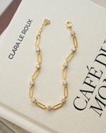 Gold plated bracelet with cubic zirconia stones on a coffee table book