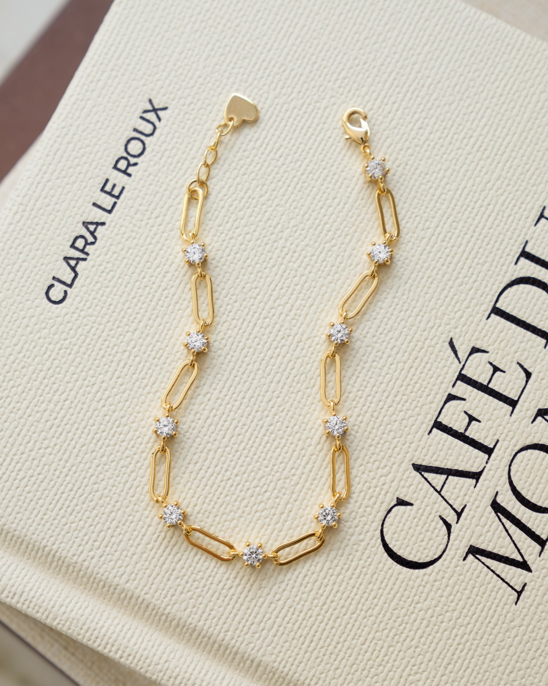 Gold plated bracelet with cubic zirconia stones on a coffee table book
