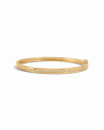 Gold bangle with small cubic zirconia pave stones on a white background
