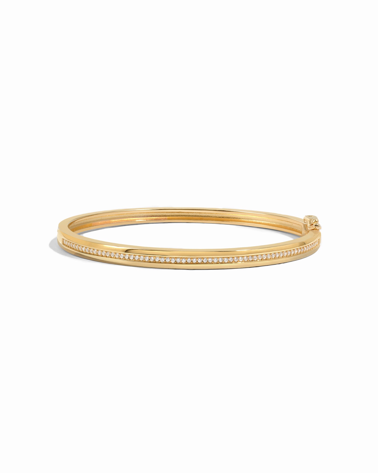 Gold bangle with small cubic zirconia pave stones on a white background