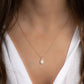 Model wearing birthstone necklace in opal with 14k gold plating