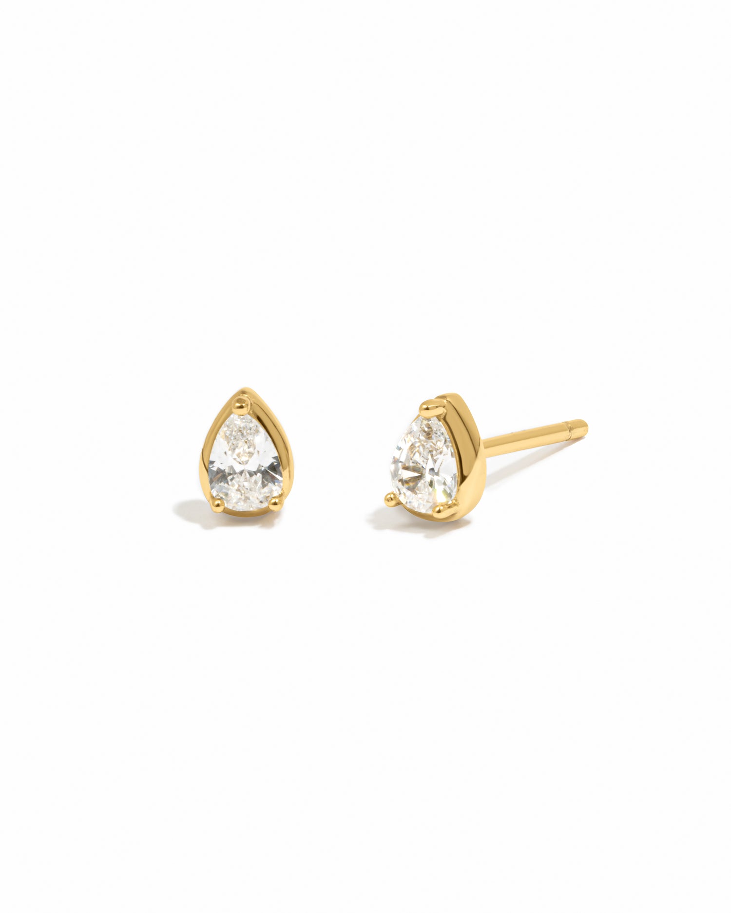 Gold teardrop earrings with white cubic zirconia gemstones on a white background