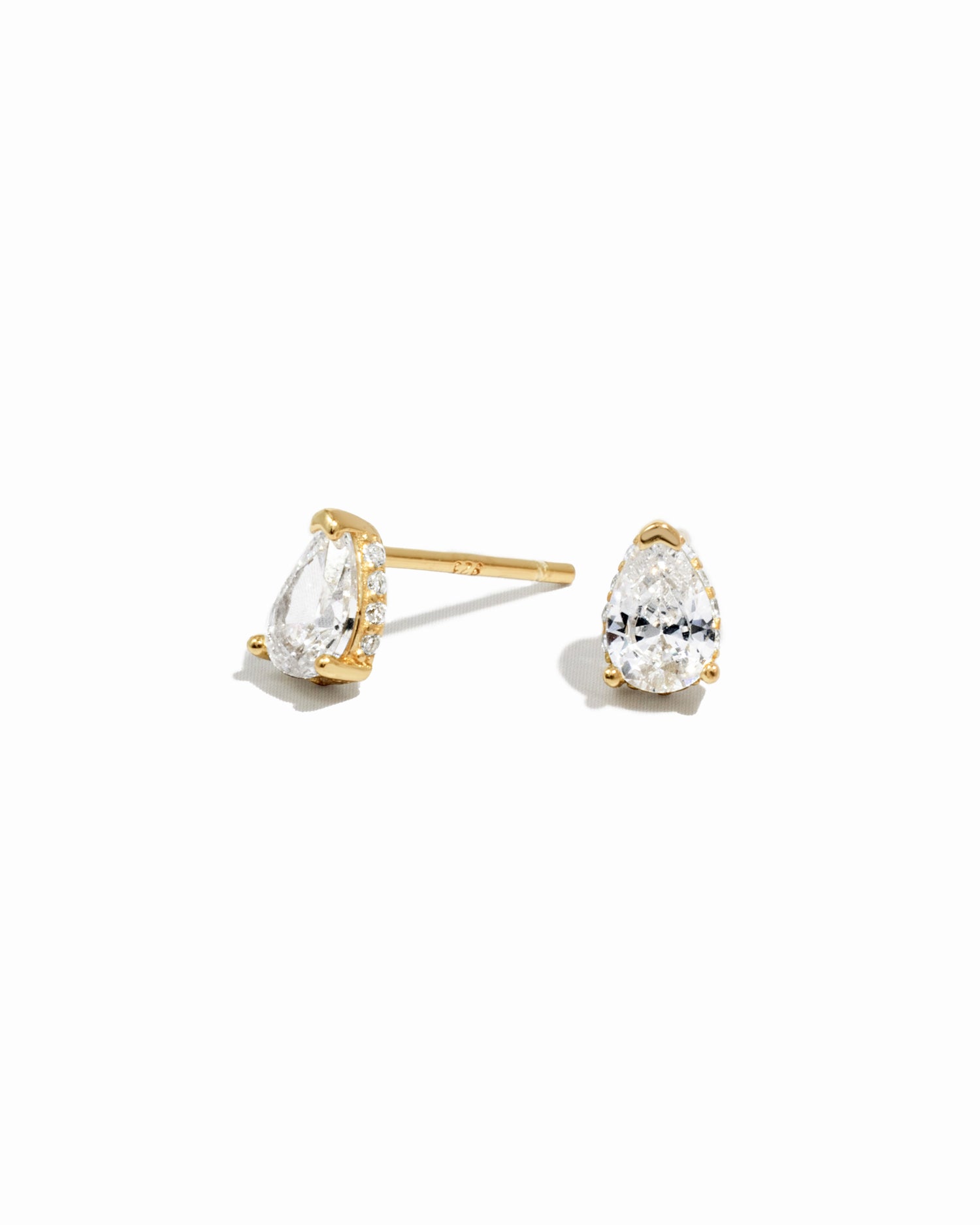 Gold pear stud earrings on a white background