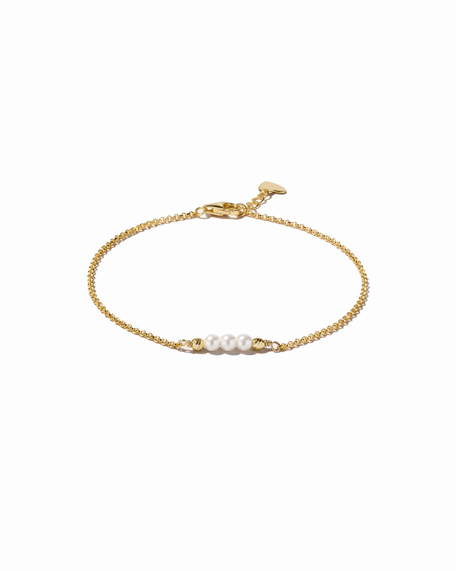 Gold bracelet with three pearls on a white background