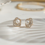 Closeup image of diamond stud earrings with 14k gold plating and pearl flower earring design