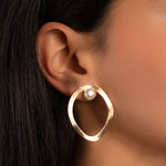 model wearing a unique earring featuring a pearl statement earring with an organic shape 