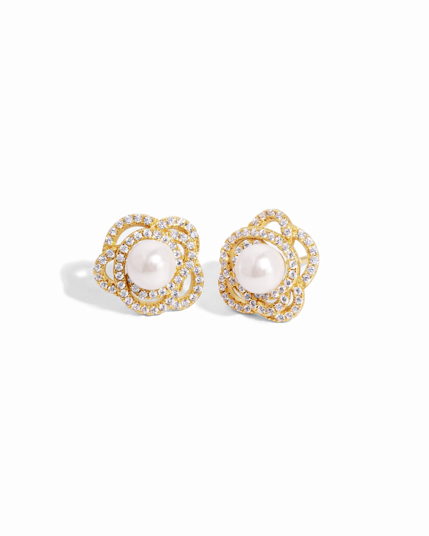 closeup image of statement earrings with pearl earring design and flower earring design in 14k gold plating 