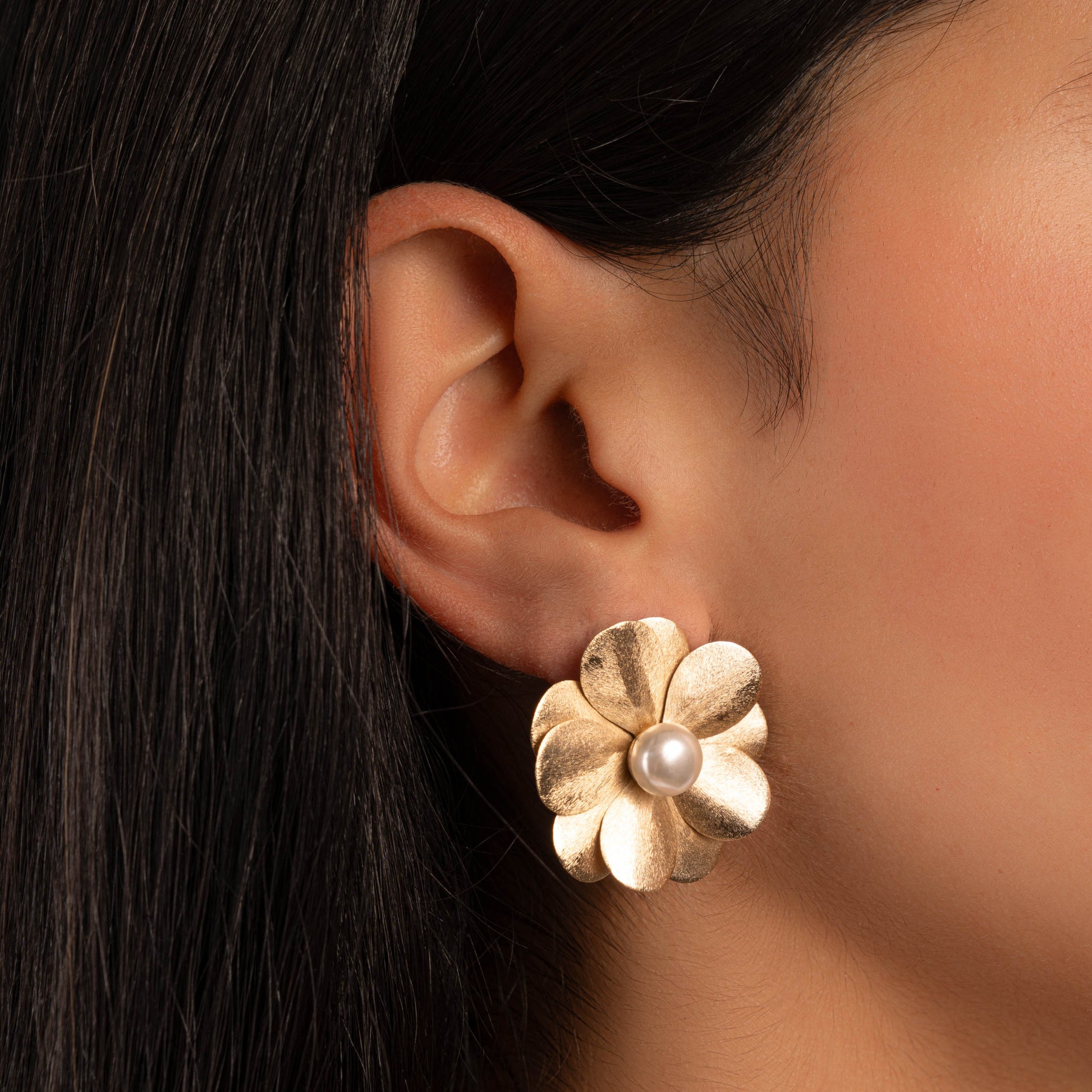 model wearing pearl jewelry featuring a pair of flower earrings