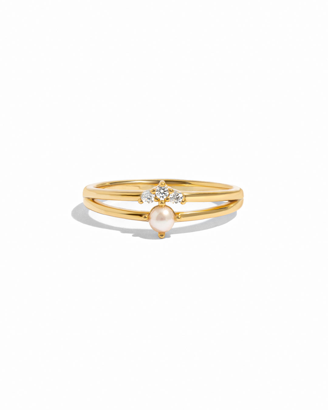 Gold ring set with a pearl and small diamond on a white background