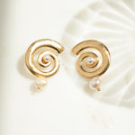 closeup image of gold shell earrings with pearl charm