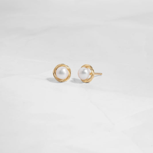 Closeup image of gold pearl stud earrings