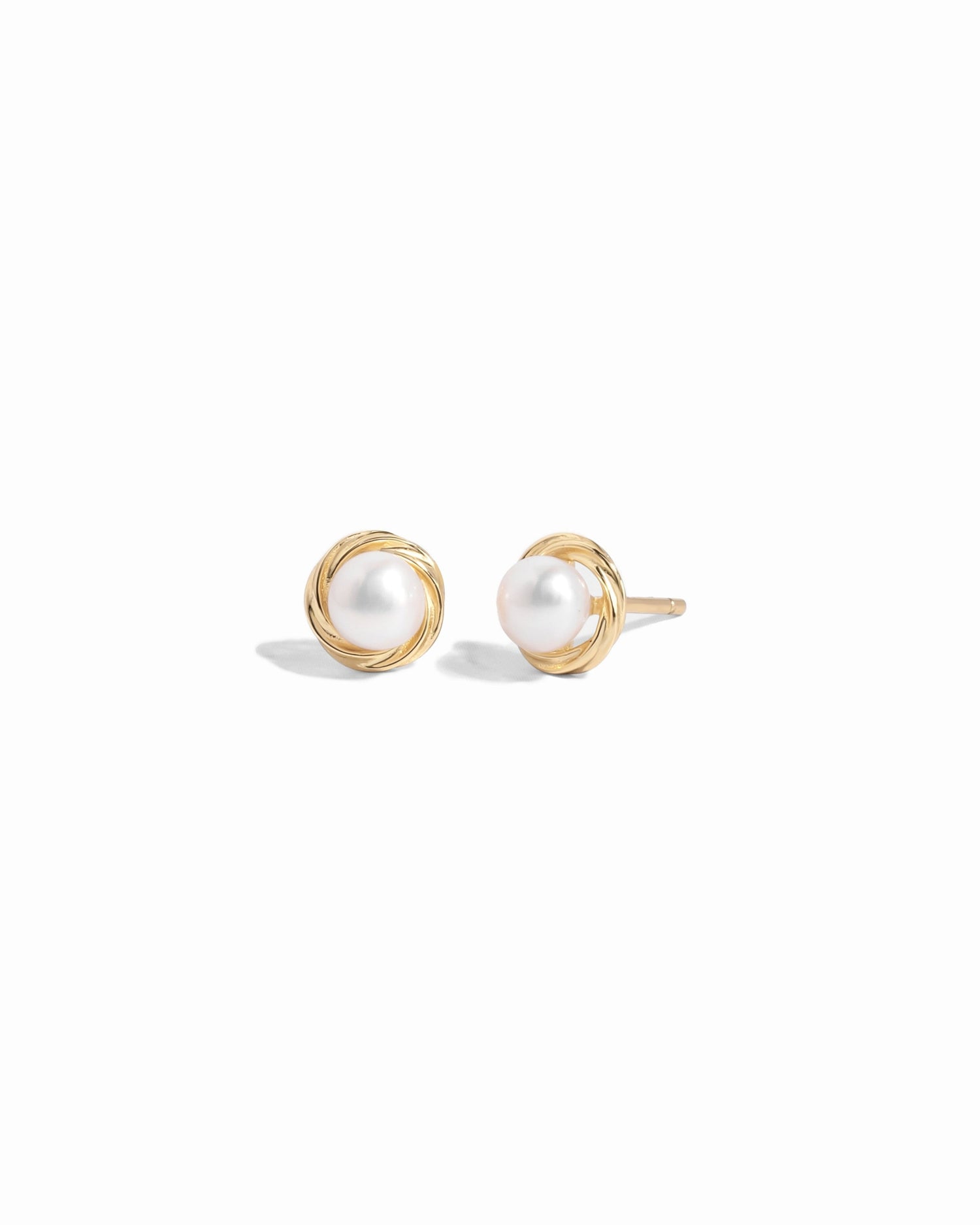 Closeup image of gold pearl stud earrings