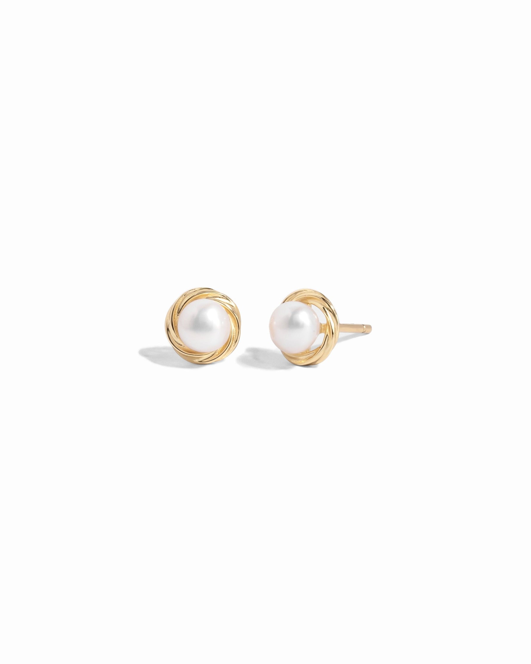 Closeup image of gold pearl stud earrings