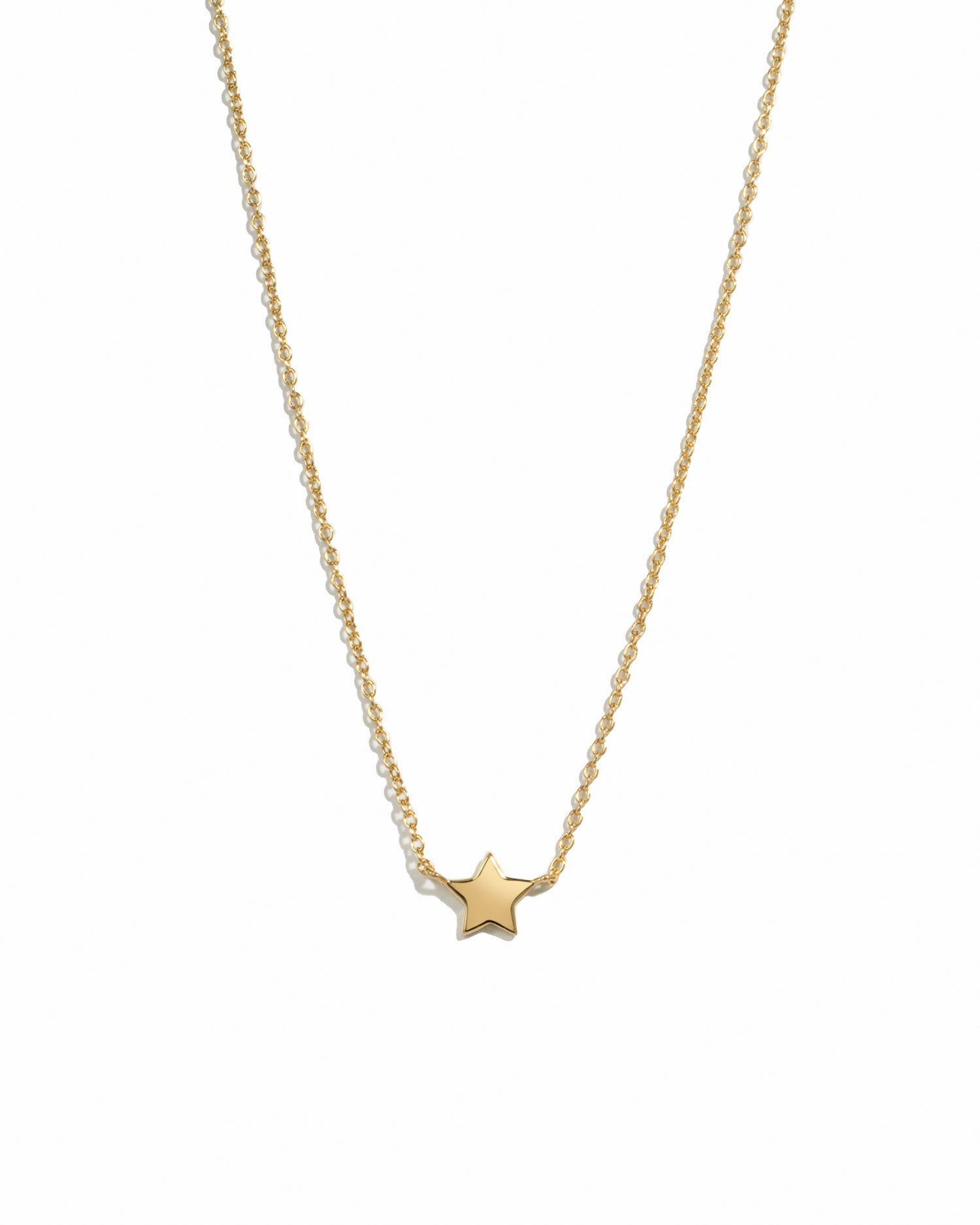 Gold star necklace on a white background