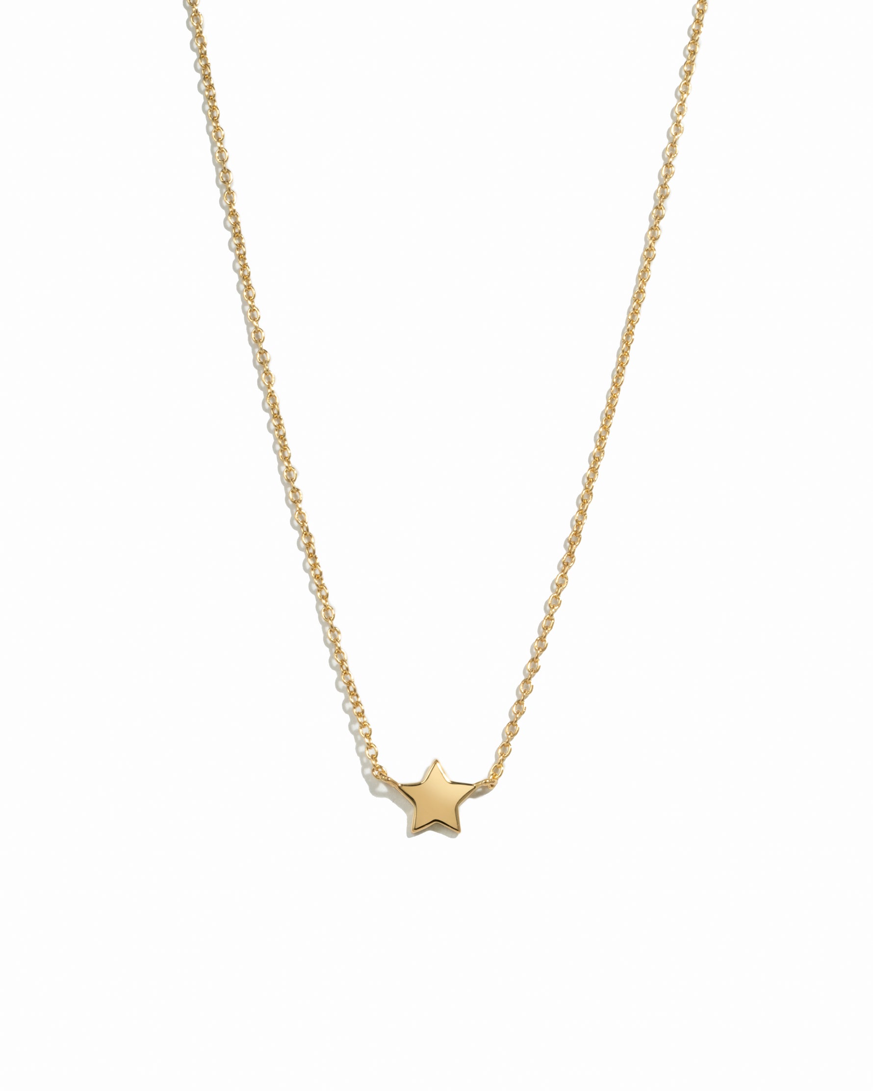 Gold star necklace on a white background