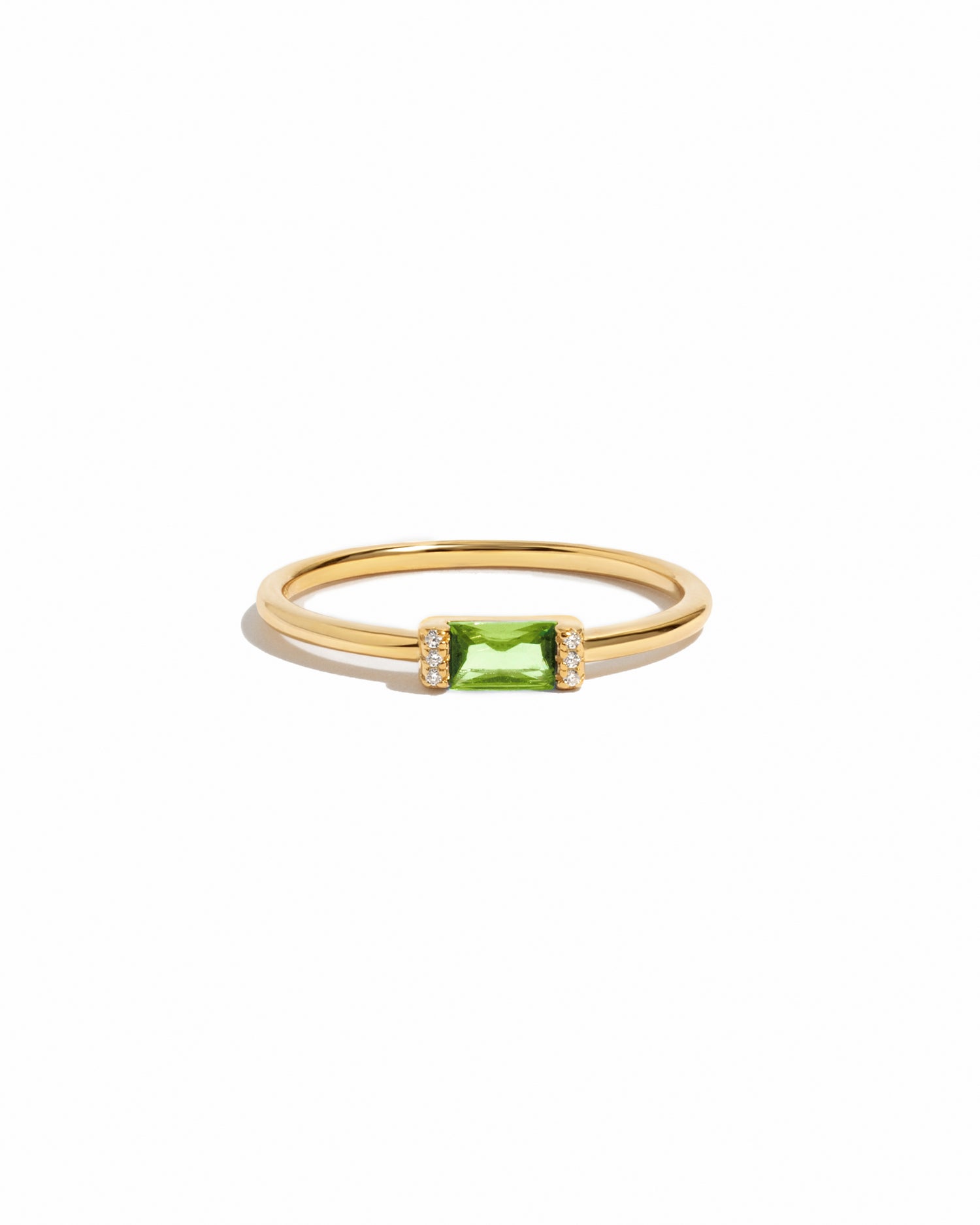 Gold peridot simple baguette ring on a white background
