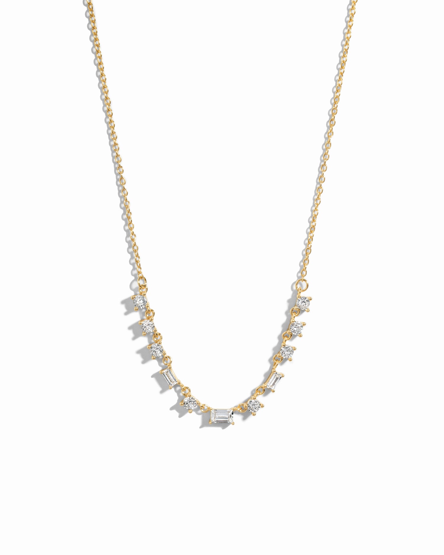 Closeup image of gold diamond baguette necklace on white background 