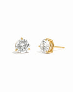 Gold stud earrings with cubic zirconia gemstones on a white background