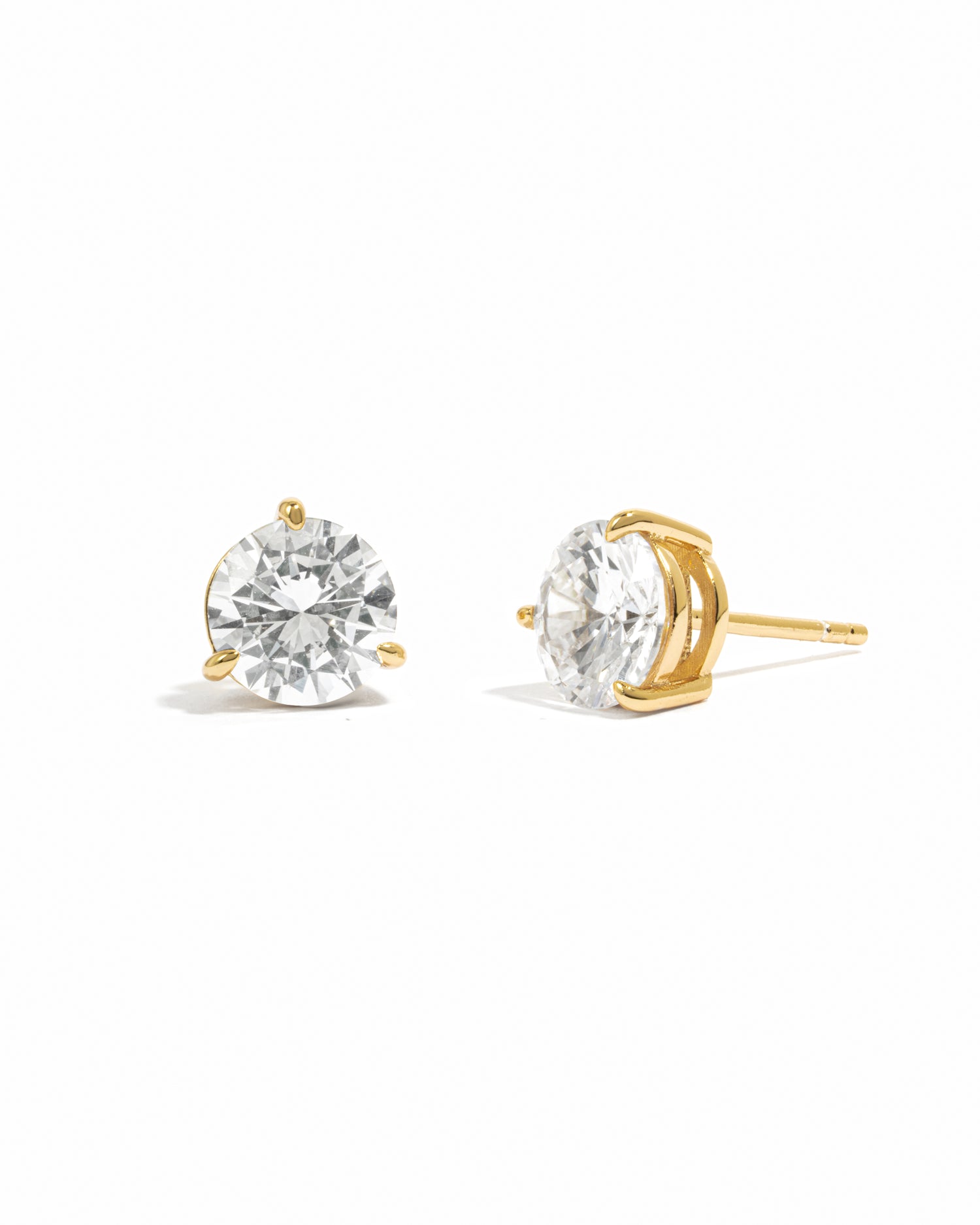 Gold stud earrings with cubic zirconia gemstones on a white background