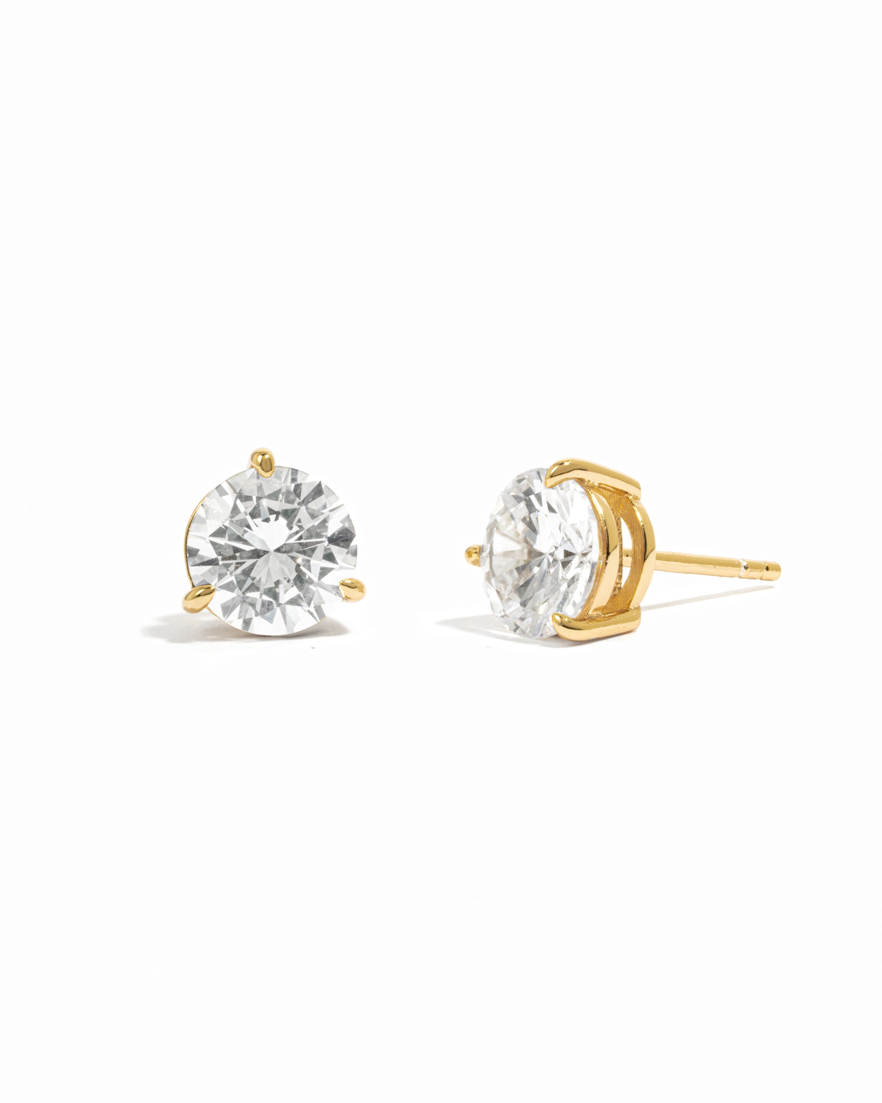Gold stud earrings with cubic zirconia gemstones on a white background