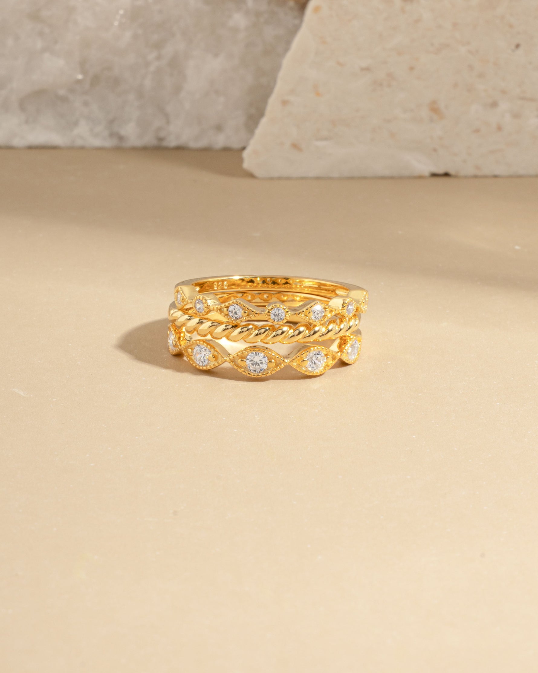 Closeup image of 14k gold plated stacking rings on marble background