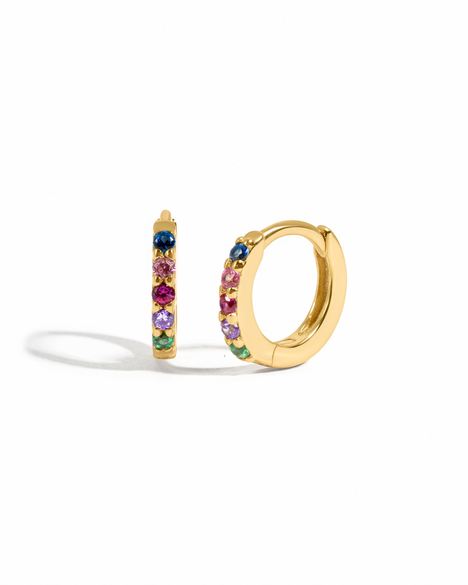 Gold hoop earrings with colorful gemstones on a white background