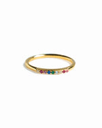 Gold ring with colorful gemstones on a white background