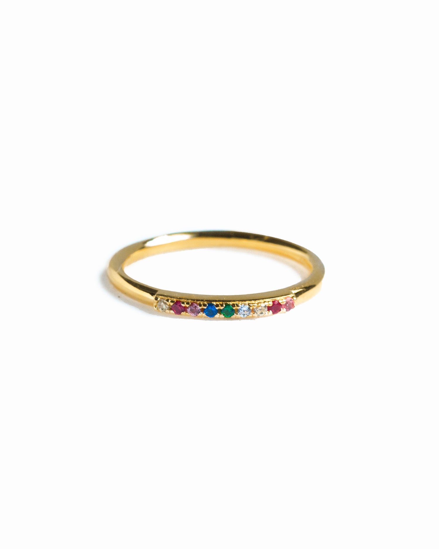Gold ring with colorful gemstones on a white background