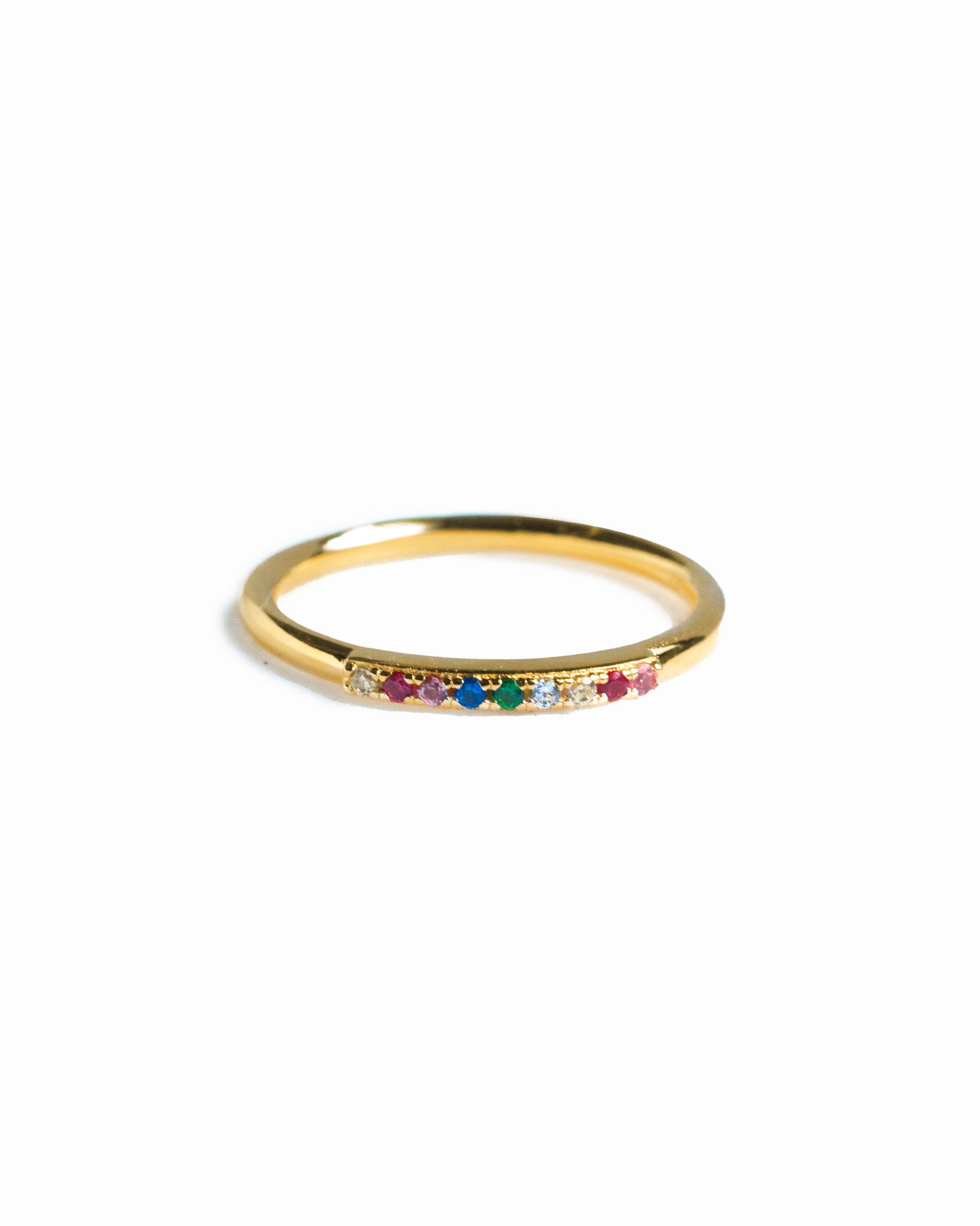 Gold ring with colorful gemstones on a white background