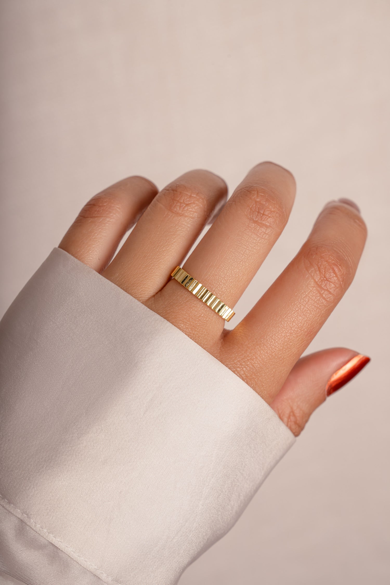 Model wearing trendy textured gold ridged ring.