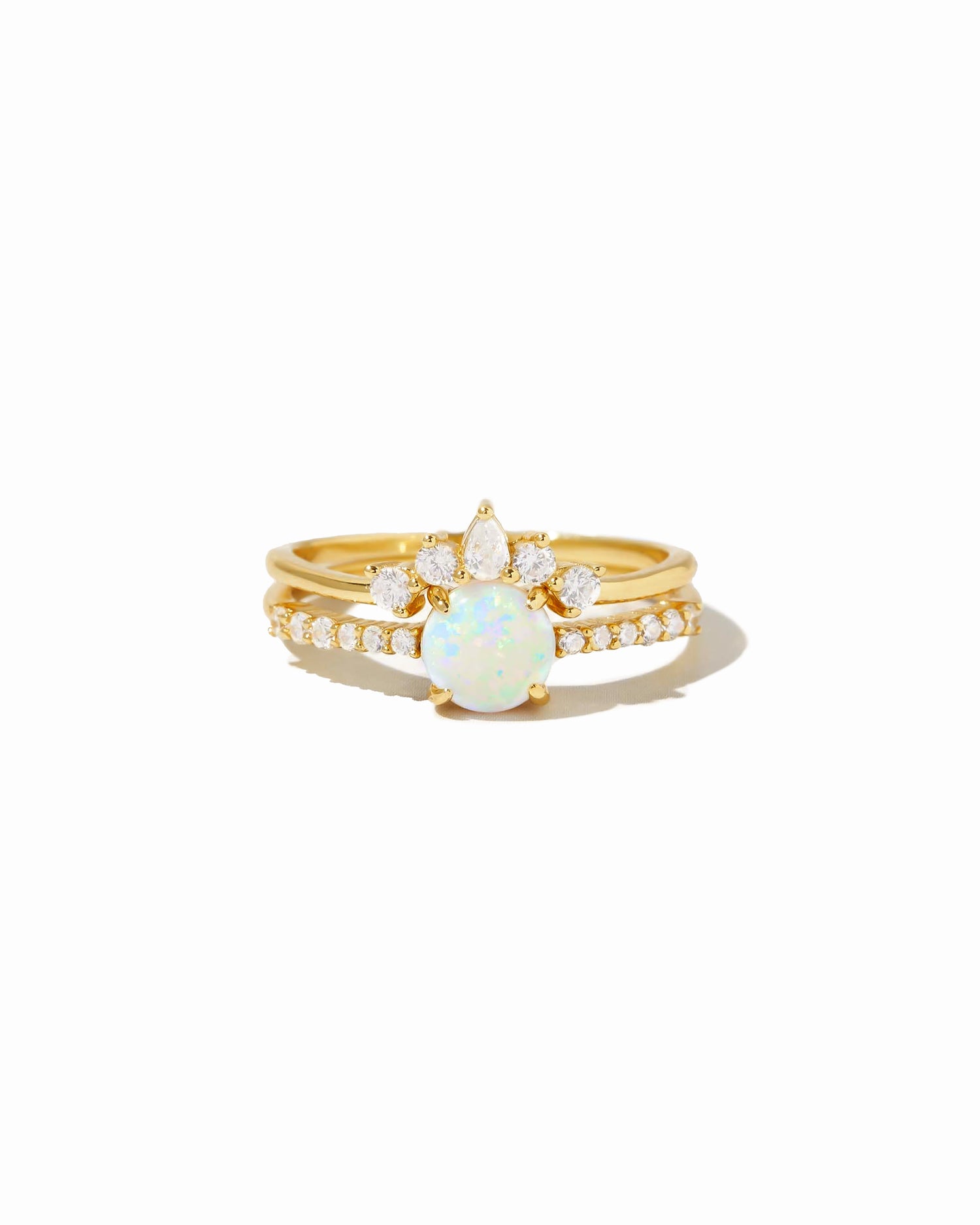 Gold ring set with a central opal stone and diamond accents on a white background