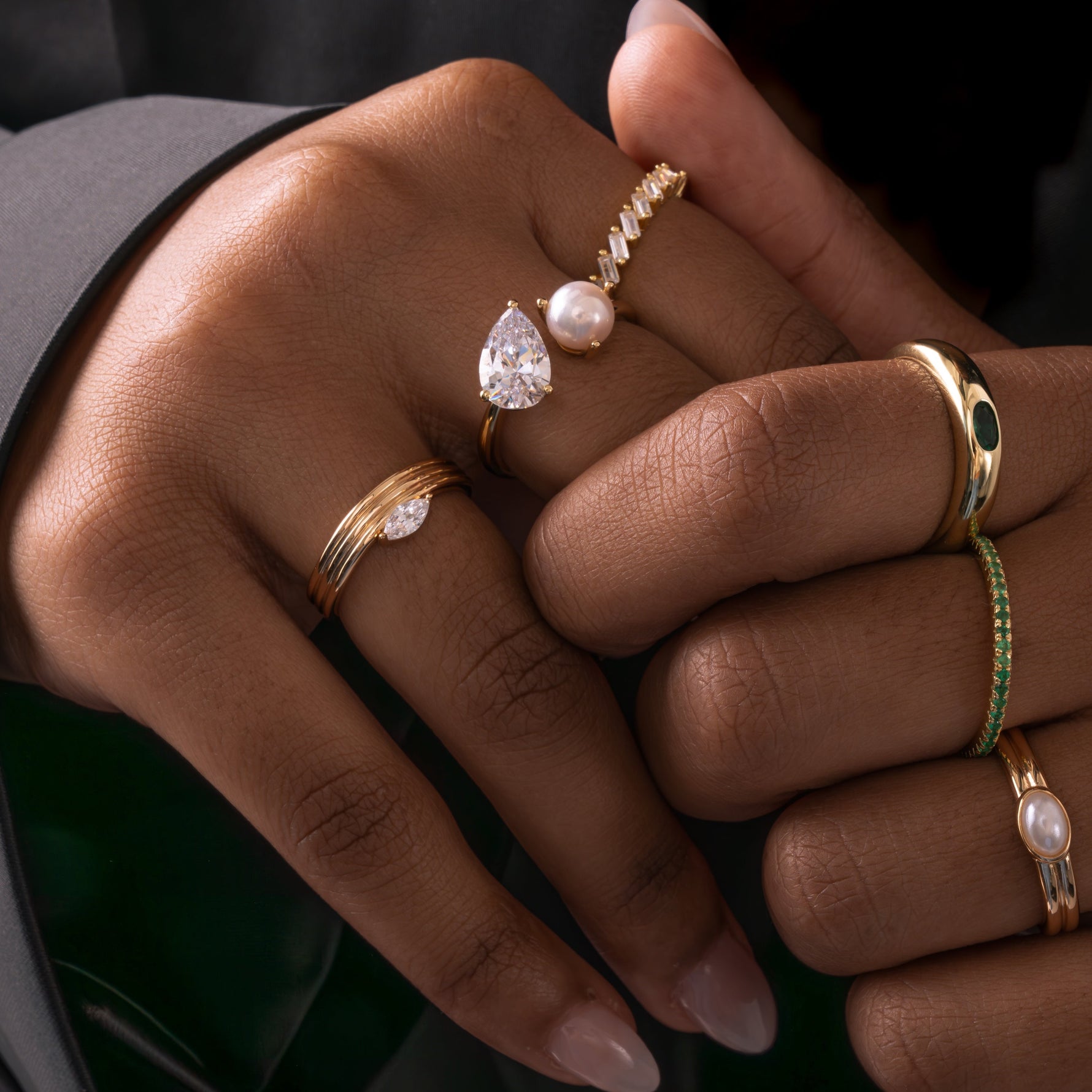 model wearing elegant gold jewelry featuring a stackable marquise cut ring 