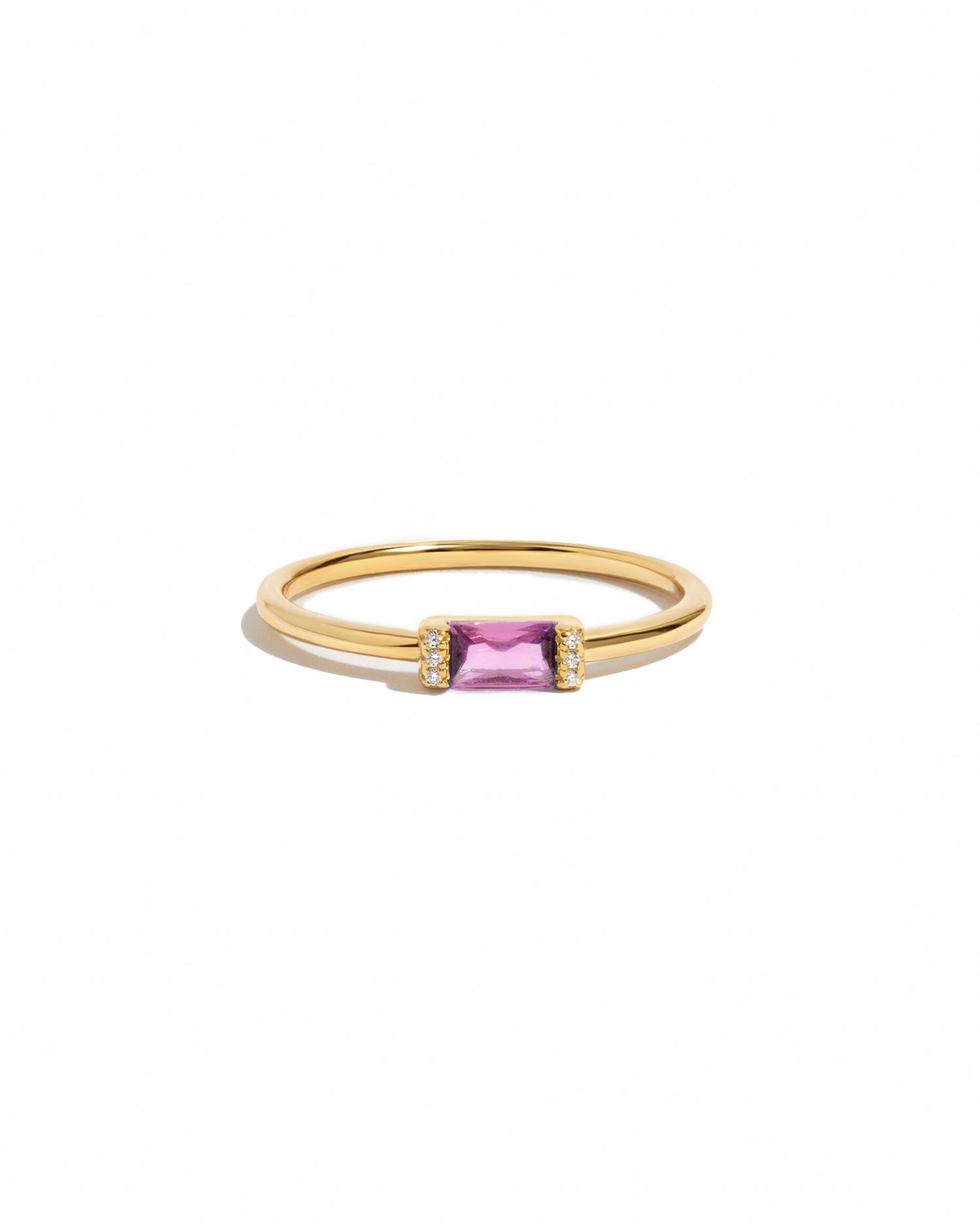 Gold ring with a pink gemstone on a white background