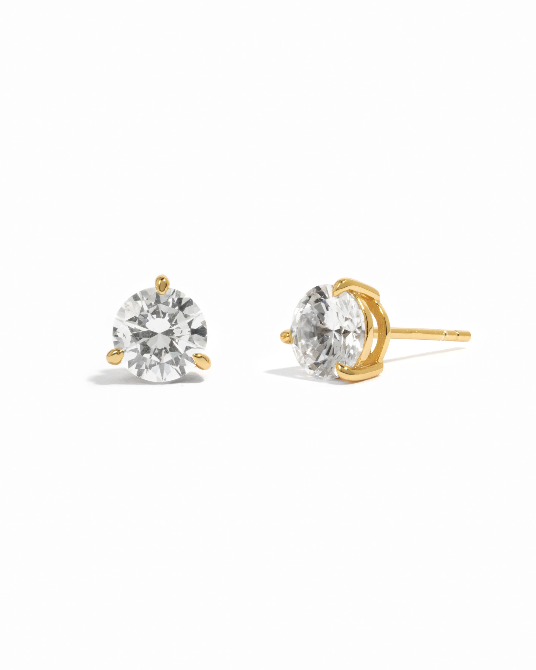 Gold stud earrings with round solitaire gemstones on a white background