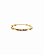 Gold ring with small ruby gemstones on a white background