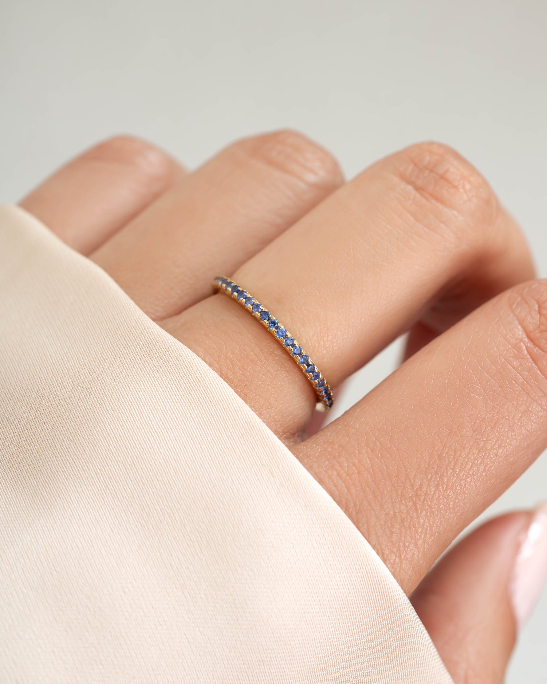 Gold sapphire eternity ring on model