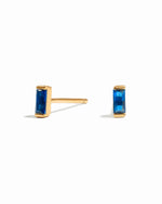 closeup image of dainty blue earrings on a white background